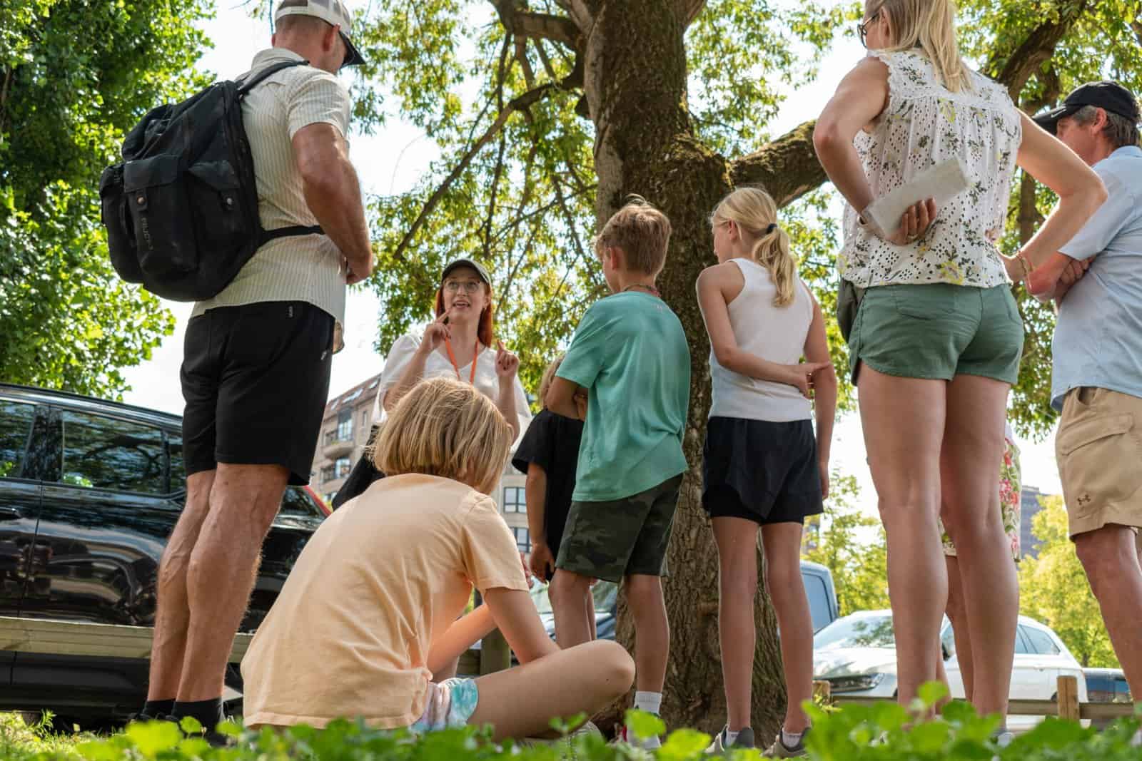 Family sitting and standing on the site of Hitler's bunker in Berlin listening to a local tour guide on a private family-friendly tour of Berlin.